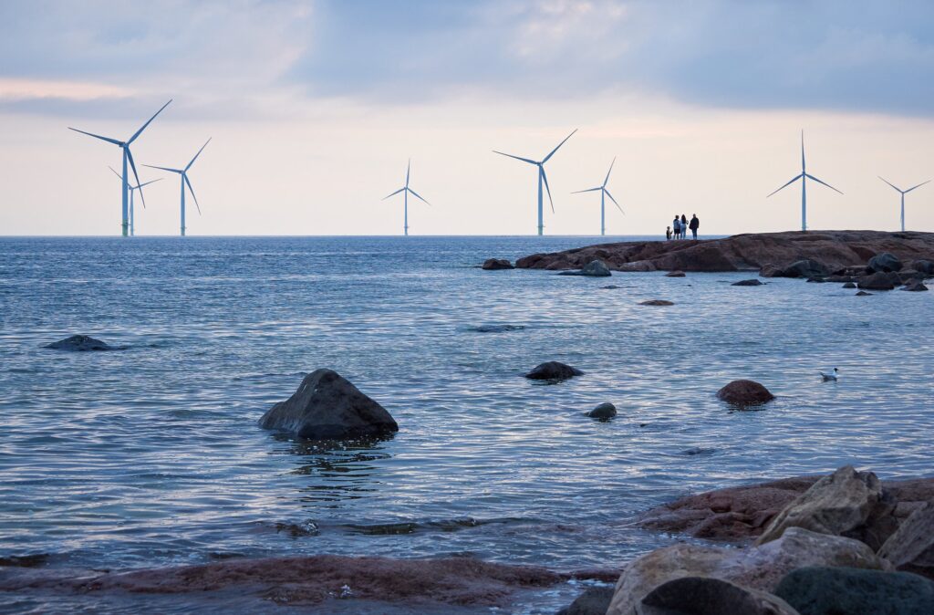 People watching wind mill power generator farm for renewable energy production along coast of Bothnian Sea near Pori, Finland. Alternative green clean energy, ecology.